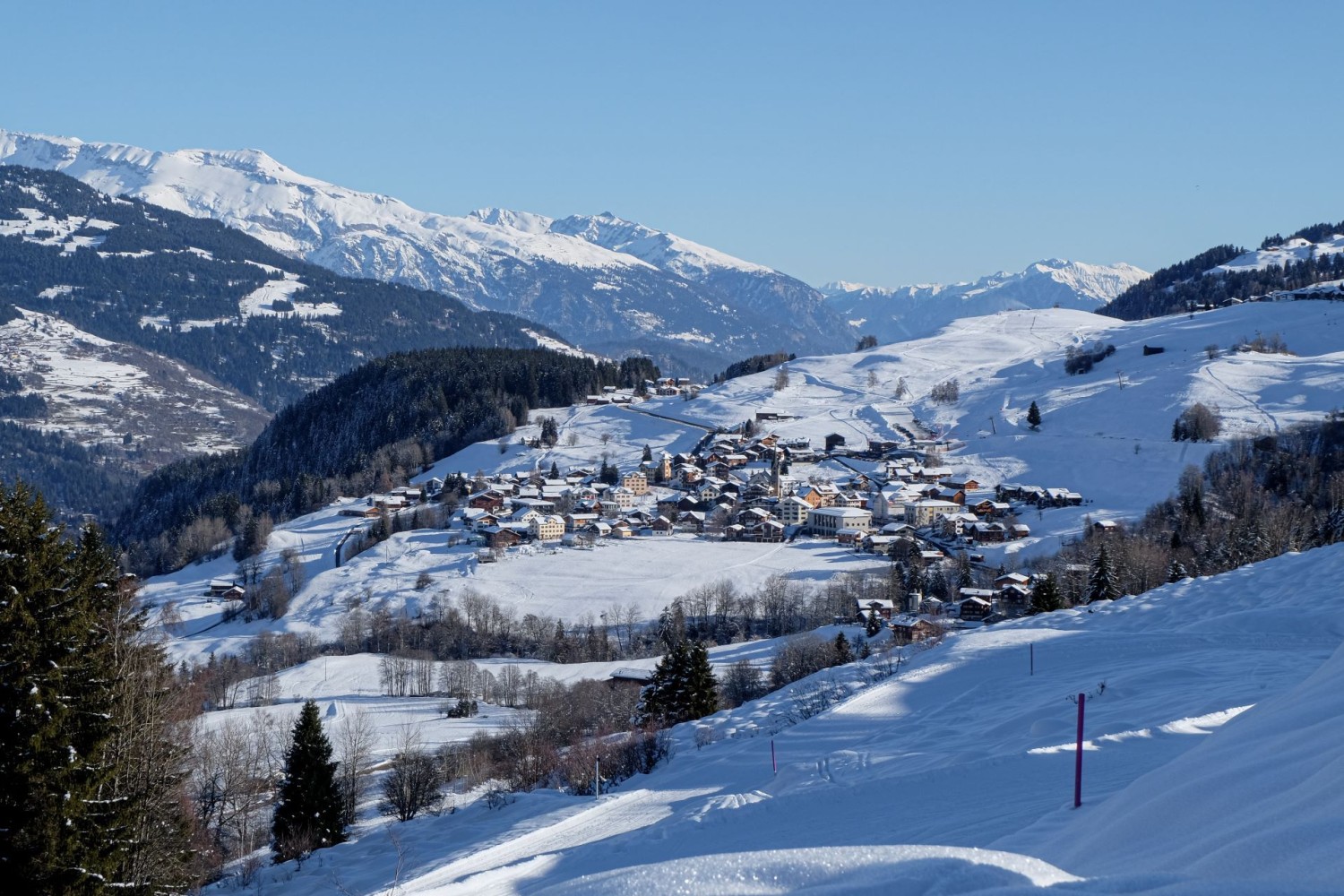 Bref coup d’œil derrière soi sur Meierhof, où débute la randonnée hivernale. Au second plan, les montagnes de la Surselva.